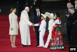El papa Francisco es recibido por el presidente mexicano, Enrique Peña Nieto (c), la primera dama, Angélica Rivera (i), y un grupo de niños.