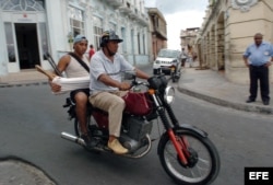 Un motorista lleva en su mototaxi a un pasajero por las calles de Santiago de Cuba.