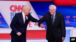 Joe Biden saluda a Bernie Sanders en el debate. 