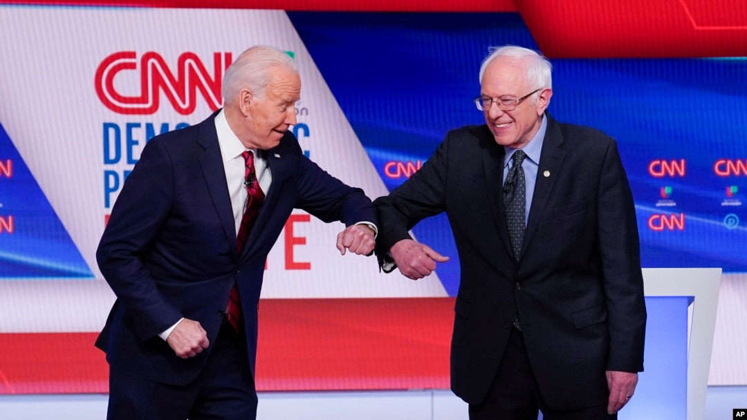 Joe Biden saluda a Bernie Sanders en el debate. 