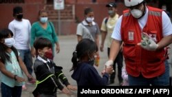 Voluntario de la Cruz Roja entrega alimentos a los niños migrantes hondureños