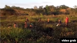 Niños cazando clarias en el fango en la presa seca del Parque Lenin.