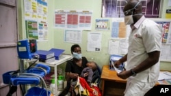 Un médico atiende a una paciente y su hijo en una clínica de Nairobi, Kenia. (AP/Brian Inganga)