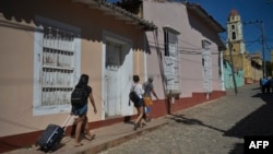Turistas caminan por una calle de Trinidad, ahora desolada por las restricciones de la pandemia. (YAMIL LAGE / AFP)