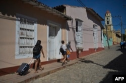 Turistas caminan por una calle de Trinidad. (YAMIL LAGE / AFP)