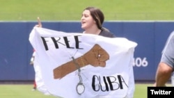 Kiele Cabrera se lanzó al terreno de juego con un cartel que pide la libertad de Cuba. (Twitter)