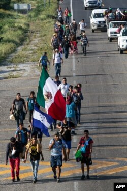 Migrantes hondureños caminan con la caravana que se dirige a EEUU.