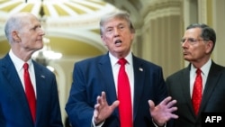Trump junto al senador Rick Scott (izquierda), republicano por Florida, y el senador John Barrasso (derecha), republicano por Wyoming, habla con la prensa en el Capitolio de los EEUU, en Washington D. C., el 24 de junio de 2026.
