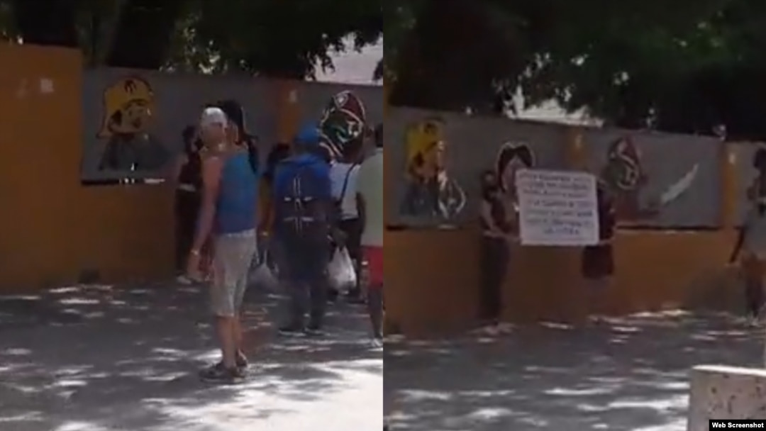 Las artistas cubanas y miembros del grupo 27N, Katherine Bisquet y Camila Lobón, alzan un cartel en apoyo a Luis Manuel Otero Alcántara.