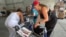 Activistas venezolanos en centro de acopio de insumos médicos para víctimas del terremoto del 24 de junio. (OCB)
