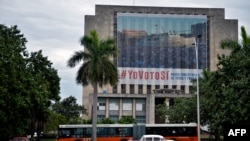 Un autobús pasa frente a un edificio con una cartelera de campaña del gobierno que dice "#YoVotoSi" en referencia a la nueva Constitución, en La Habana, el 13 de febrero de 2019