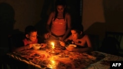 Niños comen a la luz de una vela durante un apagón en Cuba en el año 2009. 