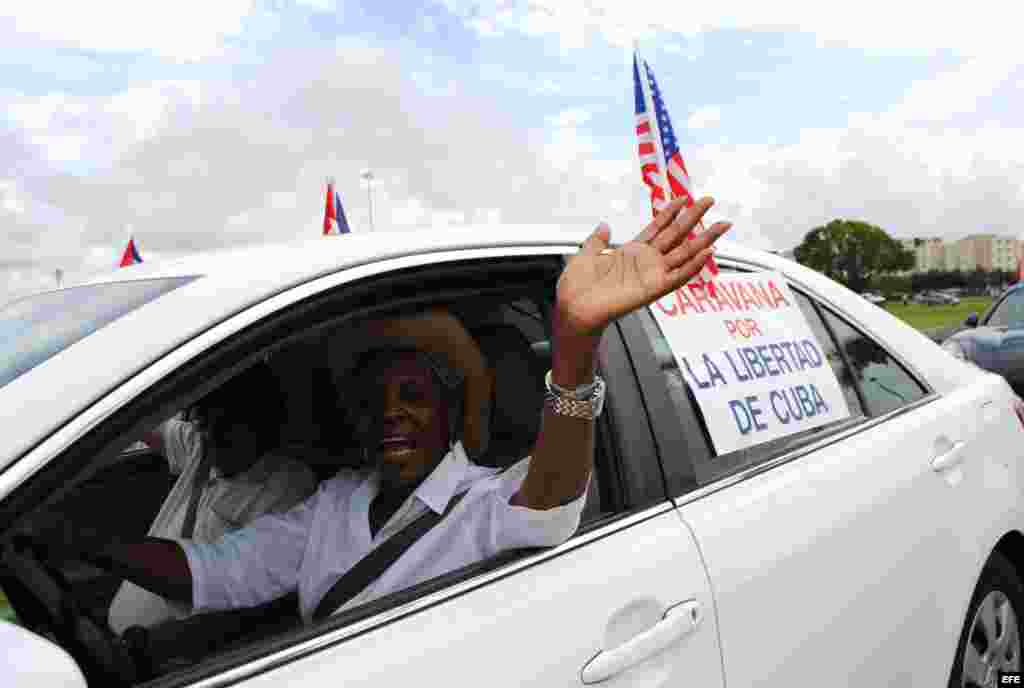 Una mujer participa, junto con unos 300 exiliados cubanos en la concentración de Miami (Florida).