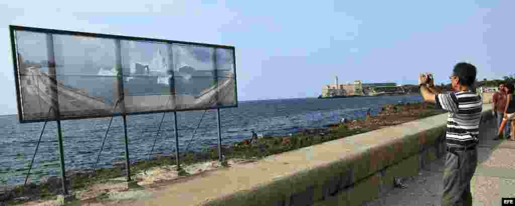 Un hombre toma fotos a las obras colocadas en el malecón de La Habana (Cuba) como parte de la XI Bienal de La Habana. 