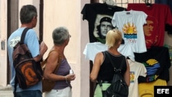 Un grupo de turistas observa varias camisetas entre las que destacan varias con la imagen del Che Guevara, en La Habana, Cuba. 