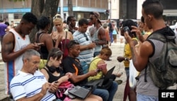 Cubanos se conectan a Internet a través de un punto Wi Fi, en La Habana.