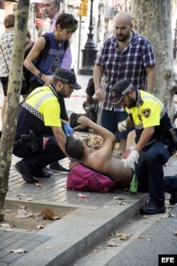 Efectivos policiales atienden a una de las víctimas en Las Ramblas de Barcelona.