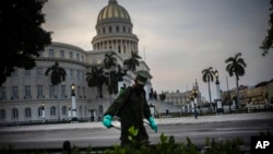 Un soldado limpia con una solución de cloro las calles aledañas al Capitolio de La Habana. (AP/ Ramon Espinosa)