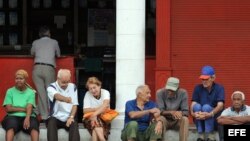 Un grupo de ancianos conversa en la puerta de una bodega en La Habana. EFE/Alejandro Ernesto