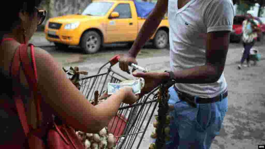 Una mujer compra cebollas con pesos cubanos en La Habana. 