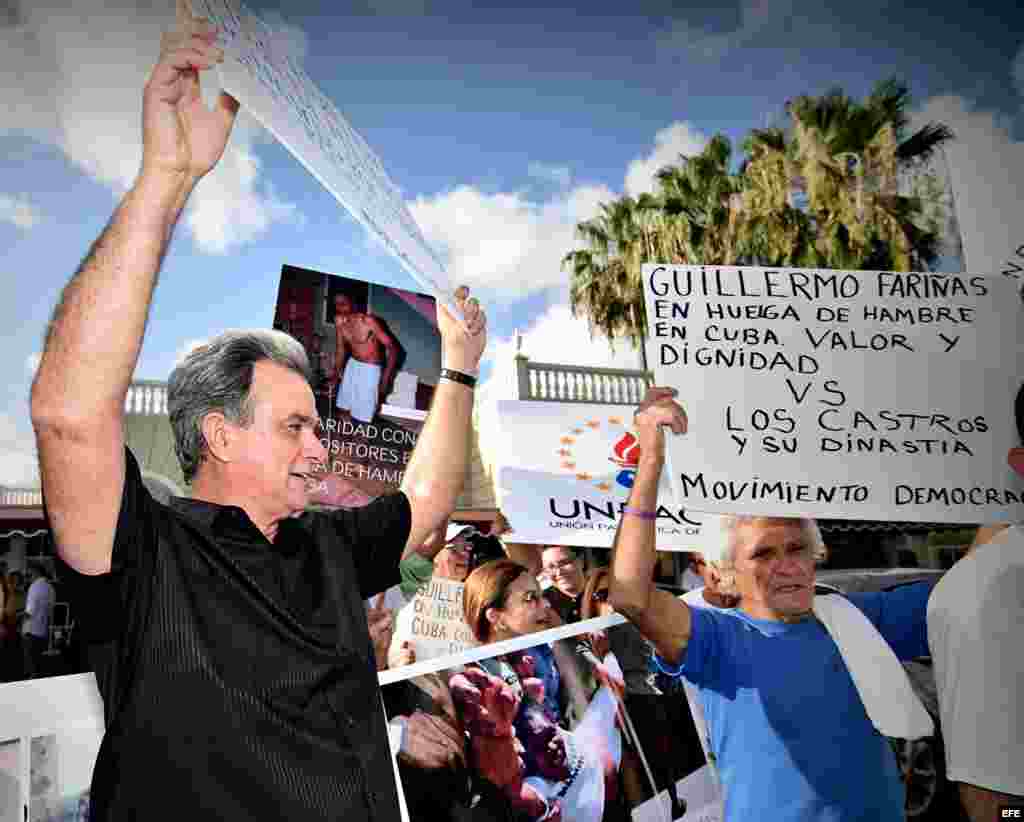 El presidente del Movimiento Democracia, Ramón Saúl Sanchez (izq.), sostiene una pancarta junto a otros cubanos durante una vigilia realizada hoy, miércoles 27 de julio 2016, frente al Restaurante Versailles en Miami.