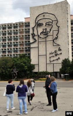 Varios turistas se toman fotos frente al Ministerio del Interior con la imagen del guerrillero argentino Ernesto 'Che' Guevara, en la Plaza de la Revolución en La Habana (Cuba).
