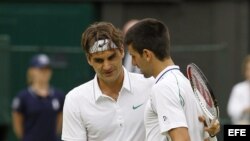 El tenista suizo Roger Federer (i) saluda al serbio Novak Djokovic (d) tras derrotarle en su partido de semifinales del Torneo de Wimbledon jugado el 6 de julio de 2012 en el All England Lawn Tennis Club de Londres, Reino Unido.