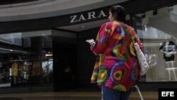  Una mujer camina frente a una de las cerradas tiendas de la franquicia que comercializa la marca española Zara en Venezuela. 
