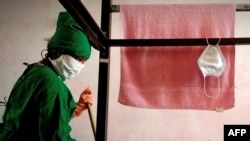 Un trabajador limpia la habitación en un centro de aislamiento para pacientes de COVID-19 en La Habana. (YAMIL LAGE / AFP)