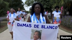 Berta Soler, líder de las Damas de Blanco, marcha por la Quinta Avenida, en La Habana, con la imagen de la fundadora del movimiento, la fallecida Laura Pollán. (Reuters/Archivo)