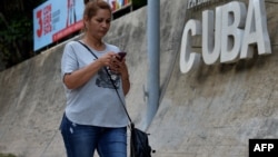 Una mujer se conecta a internet desde su celular en una calle de La Habana, Cuba. 