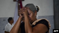 A woman prays during a mass within the National Day of Prayer for the quake victims in Valencia, Carabobo state, Venezuela, following twin earthquakes, on June 28, 2026.