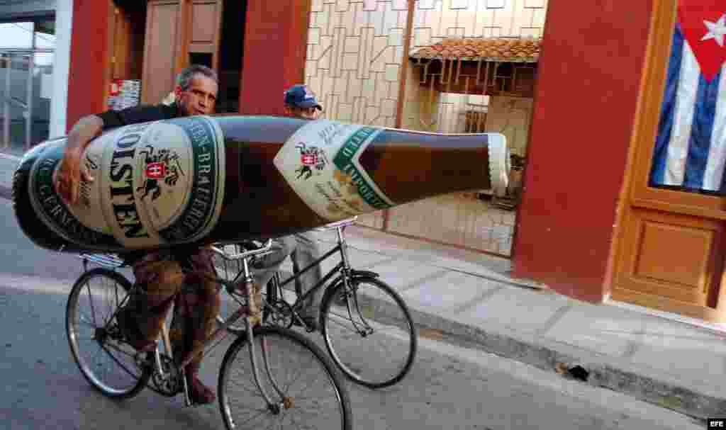 Un hombre se traslada en bicicleta con una botella de cerveza inflable, en la provincia de Camaguey, Cuba.