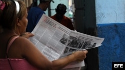 Una mujer lee el diario oficial Granma. El gobierno cubano fustiga a los periodistas independientes través de la sustracción de recursos y "arrestos breves" que les impiden hacer su trabajo.