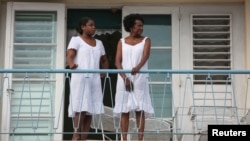 Mujeres observan desde una balcón una marcha contra la homofobia en La Habana. REUTERS/Alexandre Meneghini