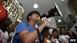  Simpatizantes del régimen cubano gritan consignas y muestran carteles durante un evento para la exhibición del documental "Conexión Cuba-Honduras", durante la visita de la cubana Yoani Sánchez.