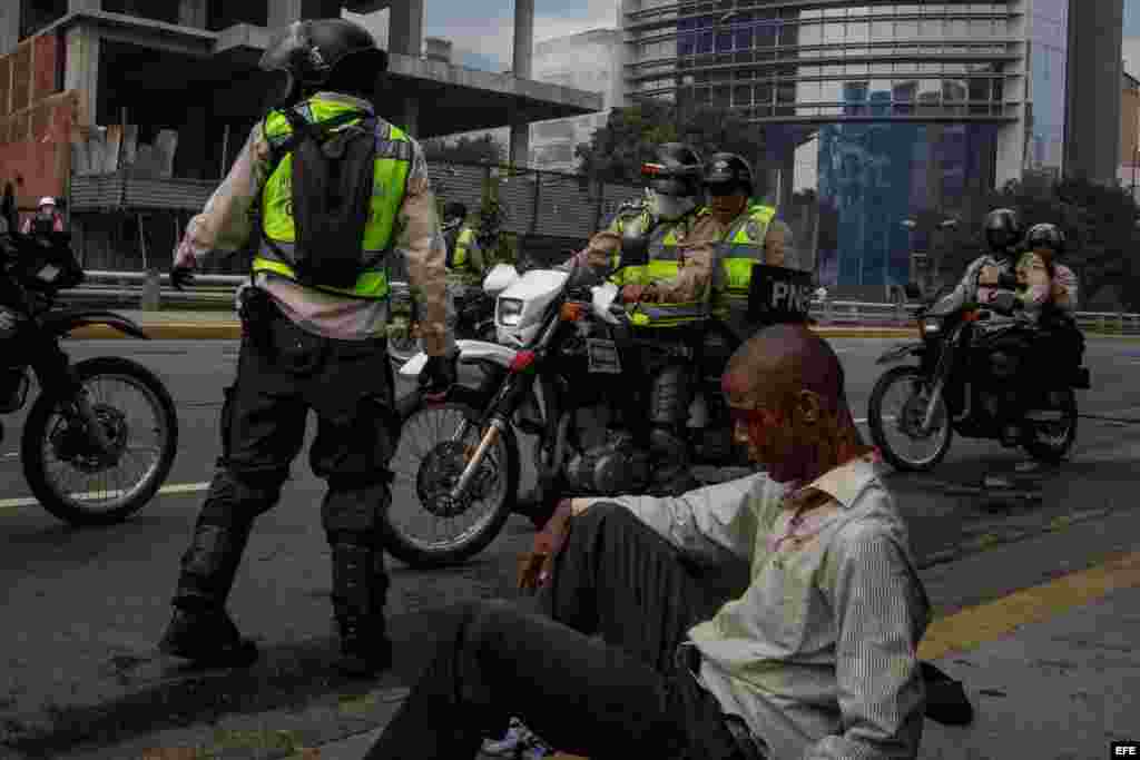 Vista de un hombre herido junto a miembros de la Guardia Nacional Bolivariana el jueves 20 de abril de 2017, en Caracas (Venezuela). La Guardia Nacional de Venezuela (GNB, policía militarizada) dispersó con gases lacrimógenos algunas concentraciones de opositores que se congregaban en diversos puntos de Caracas para marchar hacia la Defensoría del Pueblo, en el centro de la capital.