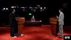 Dos personas en los atriles del escenario simulan el debate presidencial entre el republicano Mitt Romney (d) y el demócrata Barack Obama (i) en la Universidad de Denver, Colorado.