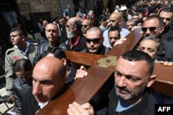 Católicos palestinos cargan una cruz a lo largo de la Vía Dolorosa, en Jerusalén.