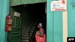 Una mujer contempla dos anuncios de negocios privados en Cuba (Foto: Archivo).