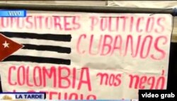 Los cubanos Rafael Hernández y Yunieski Borges desplegaron este cartel en la Plaza Bolívar de Bogotá