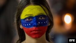 Una mujer con el rostro pintado con los colores de la bandera venezolana participa en una protesta en Caracas.
