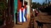Una persona camina vistiendo una bandera cubana el Alquizar. (Reuters/Tomas Bravo/Archivo)