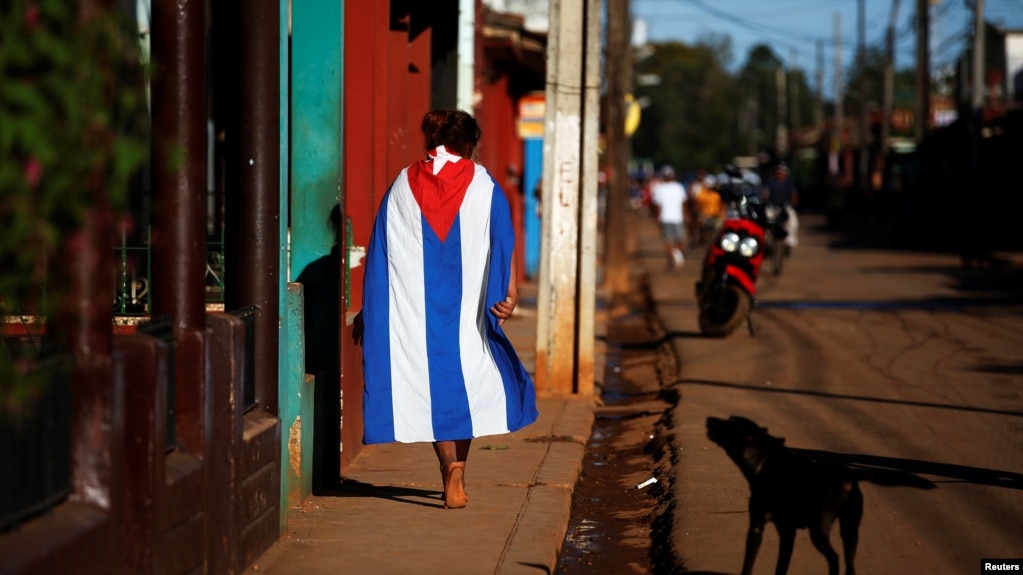Una persona camina envuelta en una bandera cubana, en Alquízar, provincia de Artemisa. (Reuters/Tomas Bravo/Archivo)