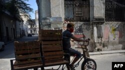 Un hombre transporta frutas en su triciclo por calle de La Habana. (YAMIL LAGE / AFP)
