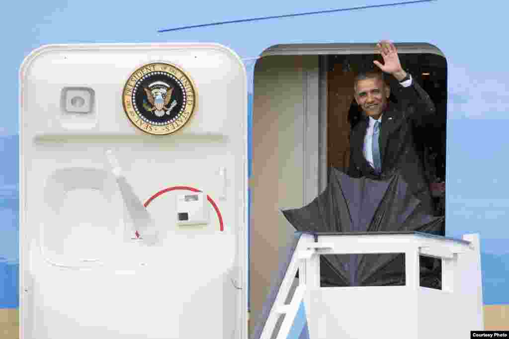 Obama aparece en la puerta del avión presidencial y saluda a los cubanos congregados en el Aeropuerto Internacional José Martí.