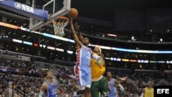 El jugador de Los Angeles Clippers Chris Paul (c-i) salta para encestar el balón