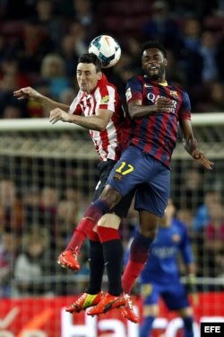 El camerunés, Alexandre Song, salta por el balón con Aritz Aduriz, del Atlético