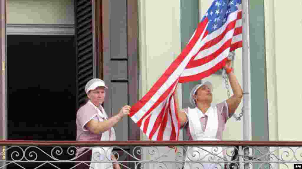Empleadas acomodan bandera estadounidense en hotel donde llegó una comitiva de senadores de EE.UU.