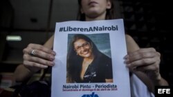 Una periodista muestra un afiche que exige la liberación de la jefa de Corresponsalías del canal venezolano de televisión Globovisión, Nairobi Pinto,